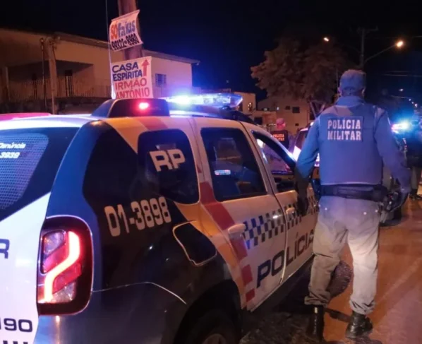 Policiais militares em volta de viatura