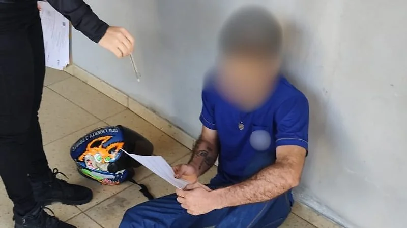 Suspeito da operação Opus Nequam sentado no chão