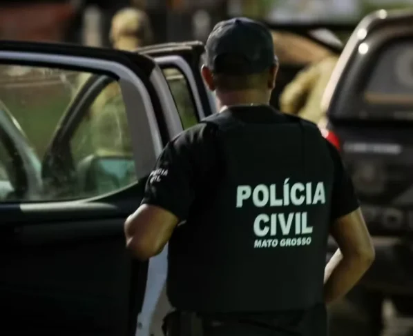 Policial civil ao lado de viatura